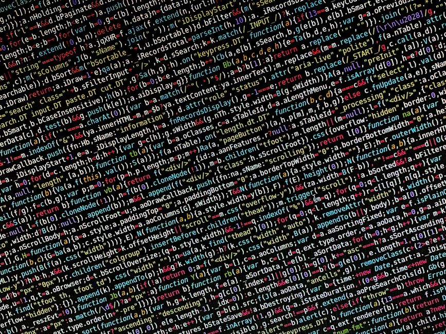 A close-up image of a computer screen displaying lines of colorful programming code, including syntax in red, green, blue, yellow, and white text on a dark background. The code features various progra